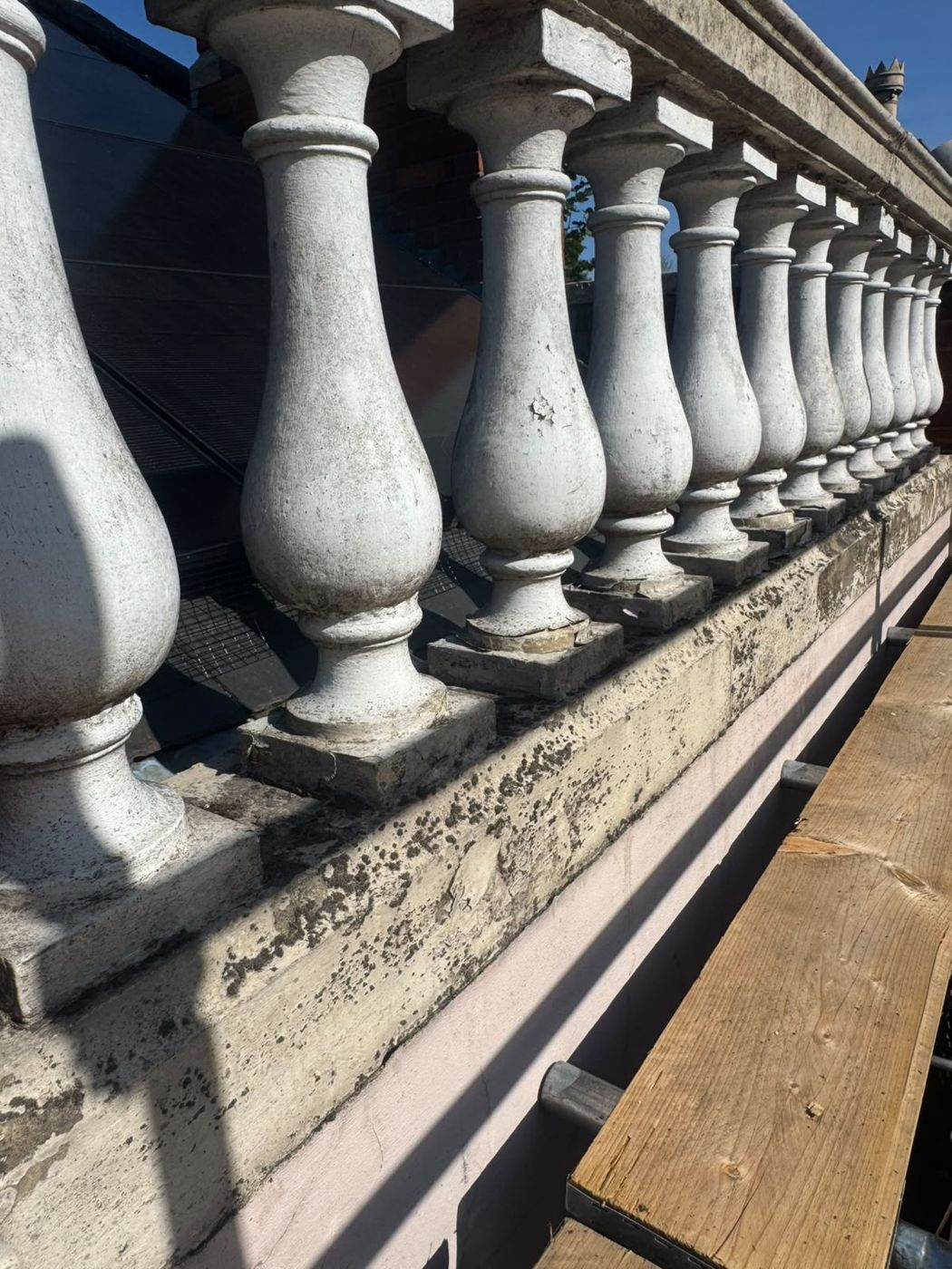 Close-up of the balusters before, with old flaking paint and staining