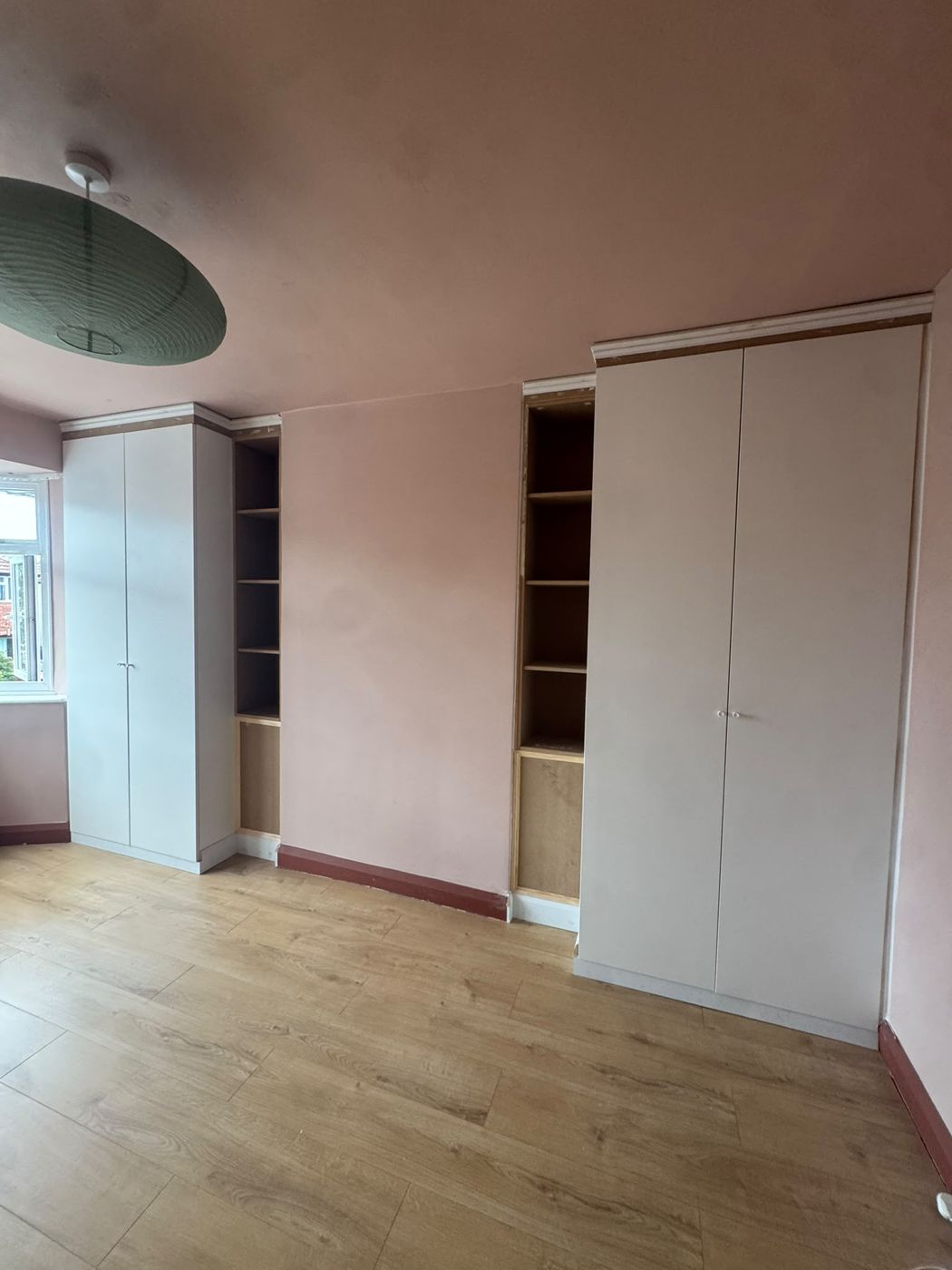 Two flat-pack wardrobes with carpenter-built shelving units and architrave trim to give a fitted wardrobe look