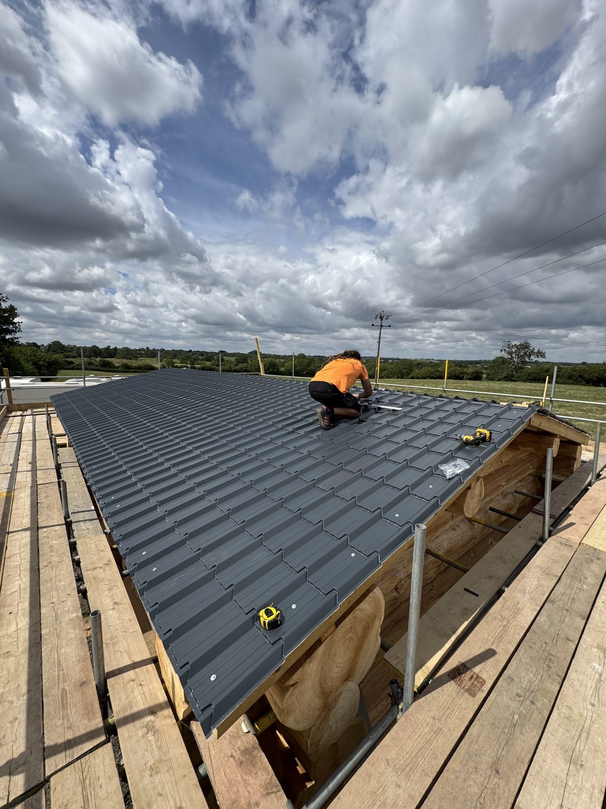 Alex fitting the roof on a hand-built timber building