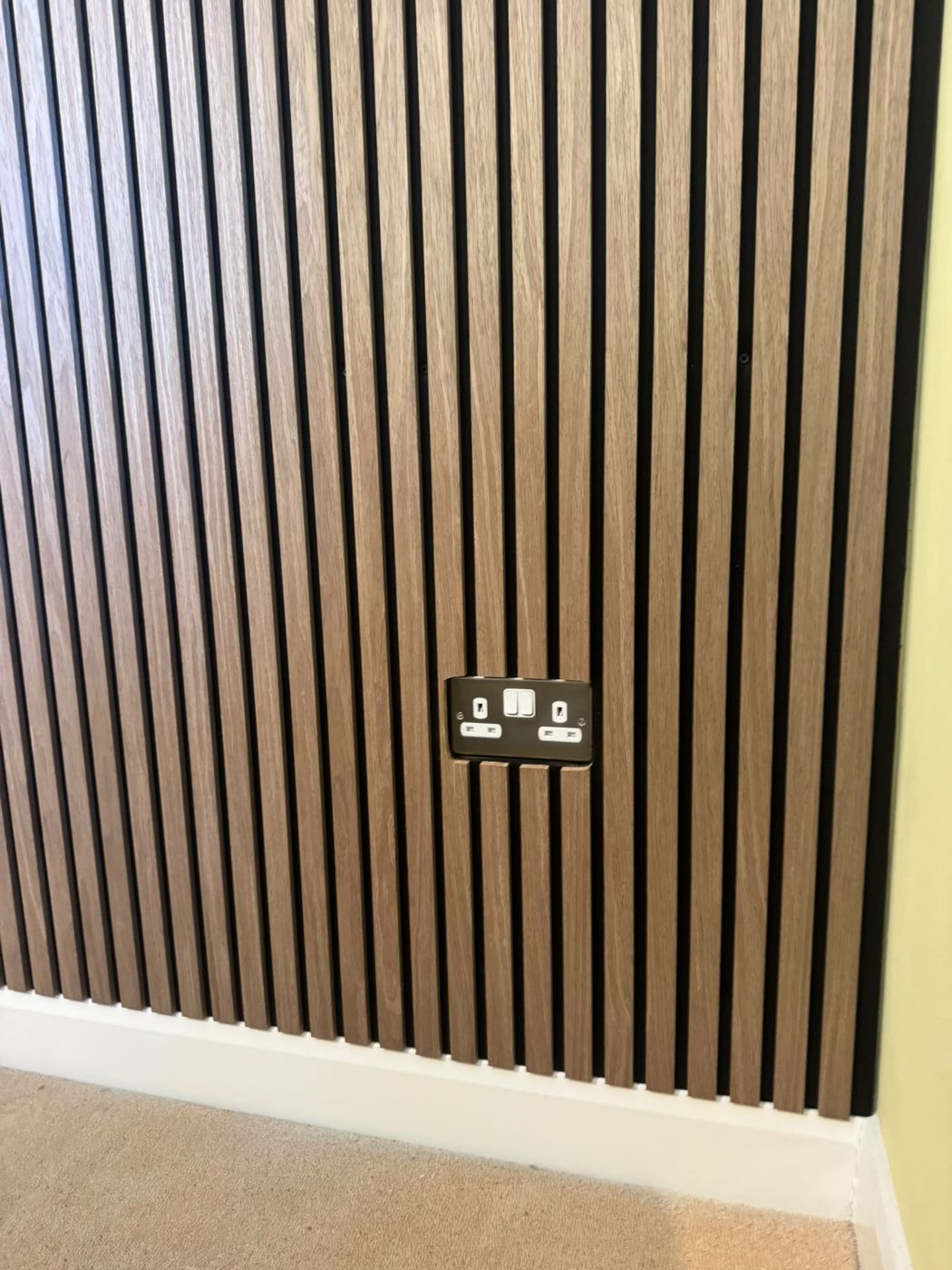 Slatted wall panelling neatly cut around a double socket