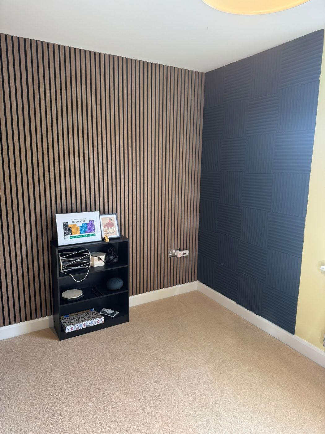 Oak-effect slat wall panelling beside acoustic foam panels in a music room