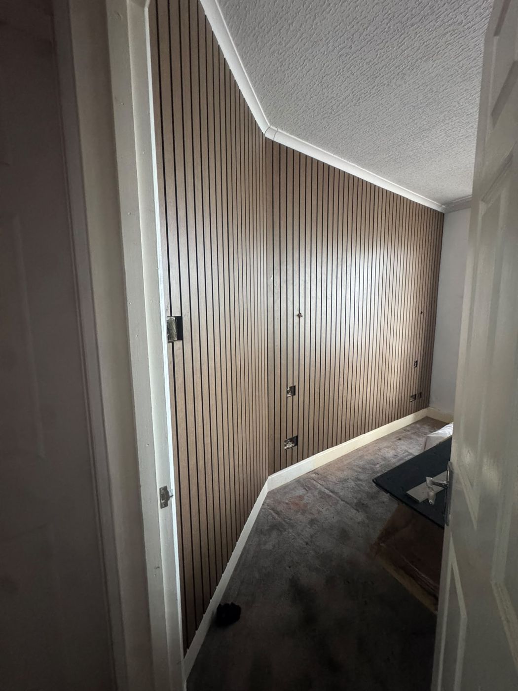 Slat wall panelling fitted along a wall and around a door frame